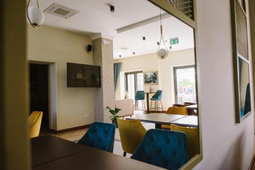 comedor con sillas azules y espejo en AVIOR Garni Hotel en Subotica