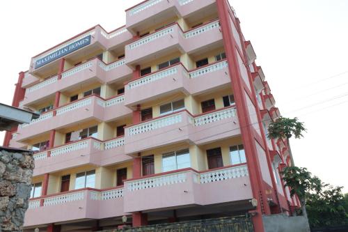 un grand bâtiment rose avec un balcon dans l'établissement MAXIMILIAN HOMES, à Kilifi