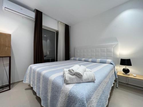 una camera da letto con un letto e asciugamani di Luxury family apartment Equilibrium a Palm-Mar