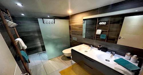 a bathroom with a sink and a toilet and a mirror at Chalet Privato con Jacuzzi New in Maspalomas