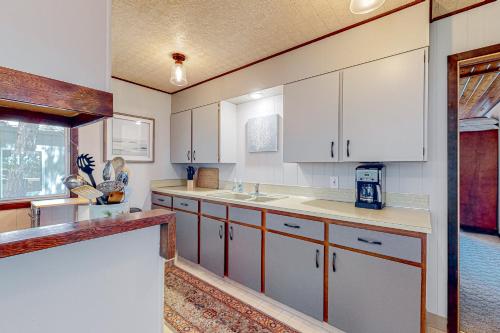 a kitchen with white cabinets and a counter top at Hidden Oasis - MCA #50602 in Manzanita
