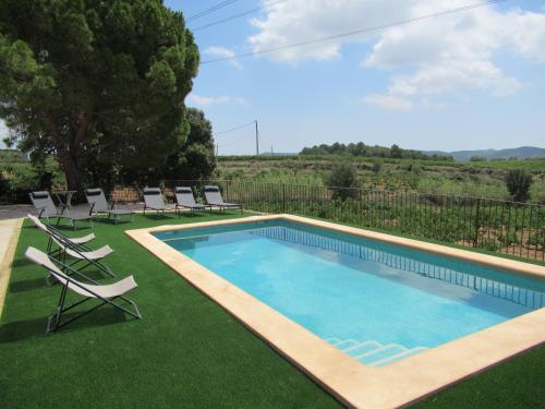a swimming pool with lounge chairs and a lawn at Casa Rural Cal Martí in El Pla de Manlleu