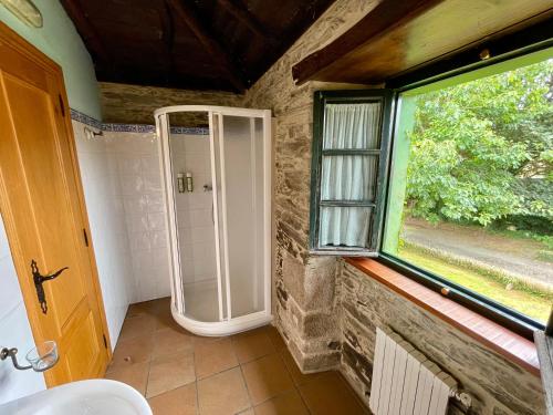 a bathroom with a shower and a window at Casa Grande do Soxal in Cesuras
