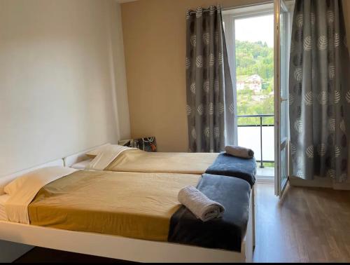 a bedroom with two beds and a large window at SplendideT4#6lits#3 chambres# Geneve/Paris/Gare in Bellegarde-sur-Valserine