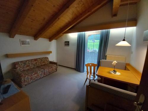 un soggiorno con divano e tavolo di Residence Alpenrose a Sesto