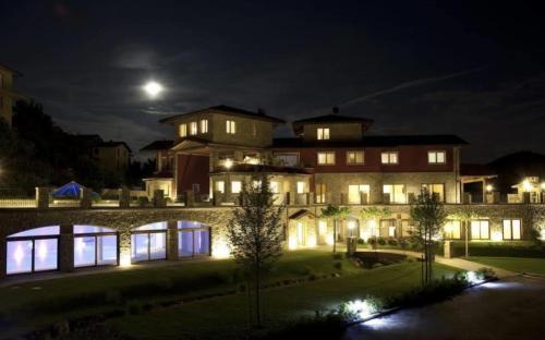 Una casa grande por la noche con la luna en el cielo en Bes Hotel Terme di Palazzago en Palazzago
