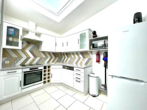 d'une cuisine avec des placards blancs et une lucarne. dans l'établissement Maison Amiens proche centre ville & gare, à Amiens