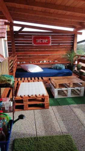 eine Terrasse mit einem Holzbett und einer Bank in der Unterkunft Králíkov01 in Tupesy