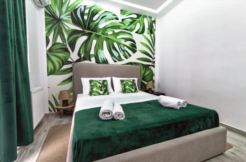 a bedroom with a green bed with a green leafy wall at Royal Luxury Suite in Athens