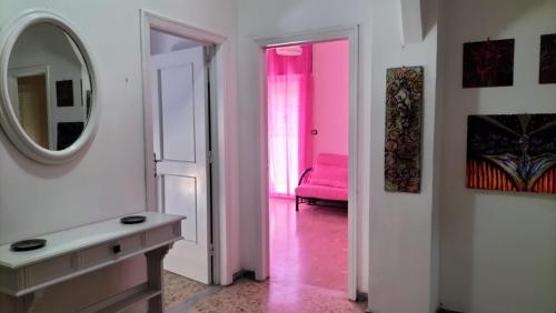 uma casa de banho com uma cadeira rosa e um espelho. em Casa Vacanza Casale em Brindisi