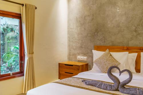 a bedroom with a bed with a swan decoration on it at Saren Kauh Ubud Palaceॐ in Ubud