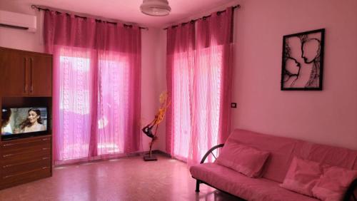 a living room with pink curtains and a couch at Casa Vacanza Casale in Brindisi