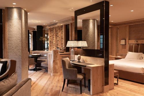 - une chambre d'hôtel avec un lit et un bureau dans l'établissement Rosapetra SPA Resort - Small Luxury Hotels of the World, à Cortina dʼAmpezzo