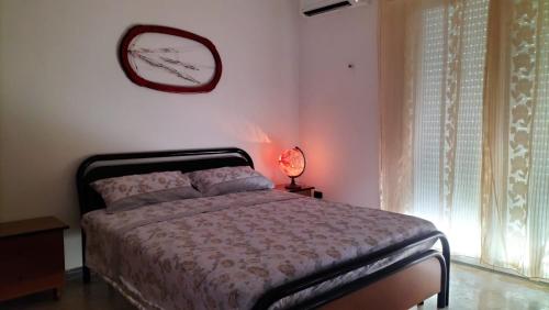 een slaapkamer met een bed en een klok aan de muur bij Casa Vacanza Casale in Brindisi