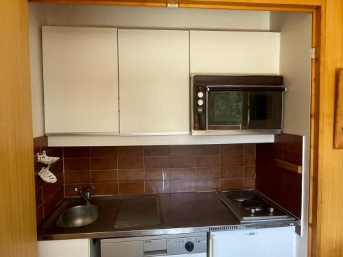 une cuisine avec un évier et un micro-ondes dans l'établissement Studio au pied des pistes pour 4 à Méribel Altiport - FR-1-411-386, à Les Allues