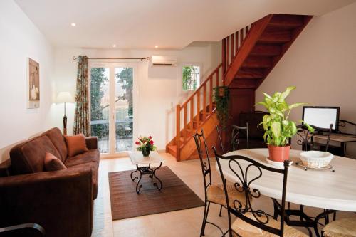 a living room with a couch and a table at Lagrange Vacances L’Oustau de Sorgue in LʼIsle-sur-la-Sorgue