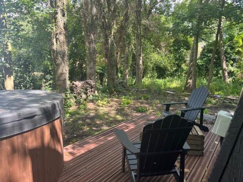 two chairs on a deck with trees in the background at La Ferme 1851 - Cabane Spa Nordique privé vue sur champ in Willems