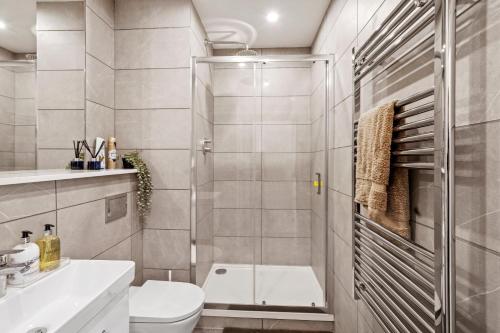 ein Bad mit einer Dusche, einem WC und einem Waschbecken in der Unterkunft Livestay-Modern One and Two Bed Apartments in Burnt Oak London in Edgware