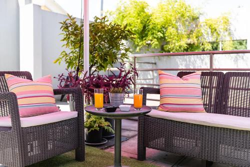 un patio con sillas y una mesa con bebidas. en Hotel ibis Guimaraes, en Guimarães