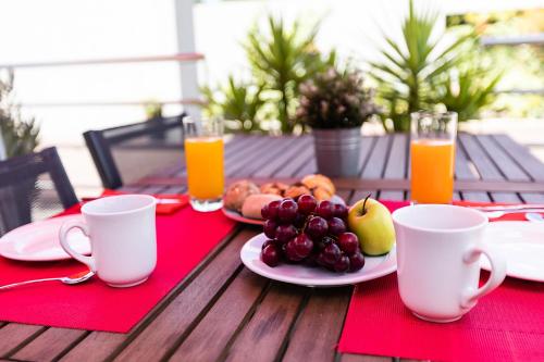 a table with a plate of fruit and orange juice at Hotel ibis Guimaraes in Guimarães