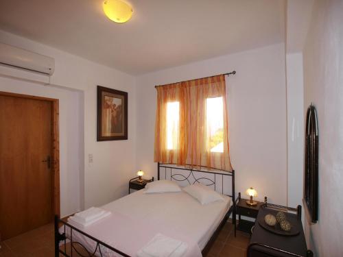 a bedroom with a white bed and a window at villa Nefeli in Lambiní