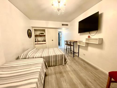 a hotel room with two beds and a flat screen tv at Apart hotel Ciudad de Bs As in Buenos Aires
