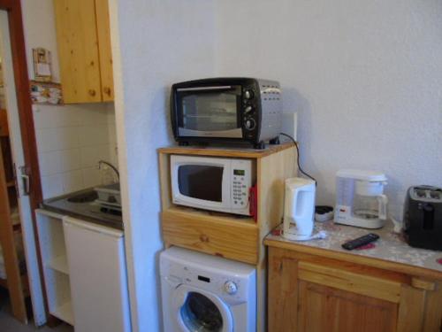 een keuken met een magnetron op een aanrecht bij Studio Valfréjus, 1 pièce, 2 personnes - FR-1-561-73 in Valfréjus