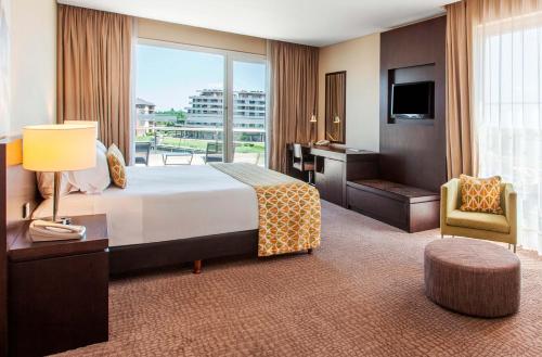 um quarto de hotel com uma cama, uma secretária e uma janela em Wyndham Nordelta Tigre - Buenos Aires em Tigre