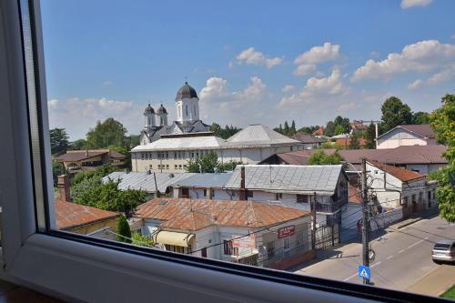 - une vue depuis la fenêtre d'une ville avec une église dans l'établissement Apartament ILEV, à Roman