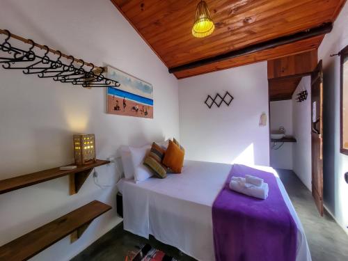 a bedroom with a large white bed in a room at Pousada Raiz Forte in Caraíva