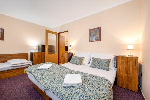 a hotel room with two beds with towels on them at Penzion a kemp Koruna in Zlatá Koruna