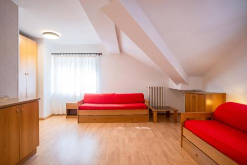 een woonkamer met twee rode stoelen en een raam bij Residence Villa Viola in Andalo