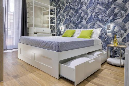 a bedroom with a white bed with drawers at Live suite Napoli in Naples