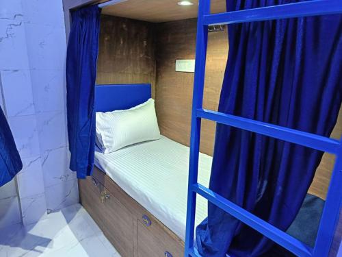 - łóżko piętrowe z niebieską drabiną w pokoju w obiekcie Kohinoor Dormitory w Bombaju