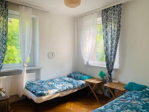 a bedroom with two beds and two windows at Tutaj Sielankowo in Ustroń