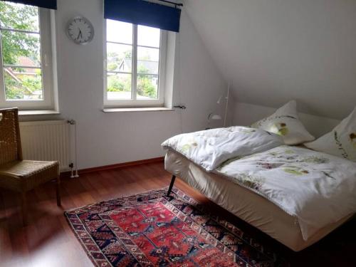 um quarto com uma cama e um relógio na parede em Ferienwohnung im Friesenhaus em Risum-Lindholm