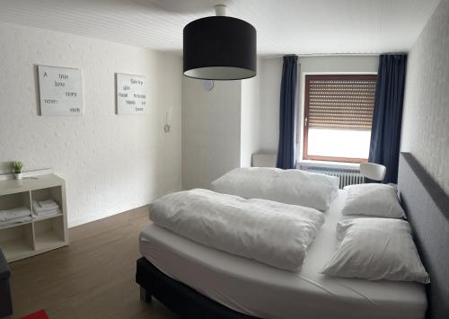 Pension Burgklause في Schönecken: غرفة نوم بسريرين ونافذة