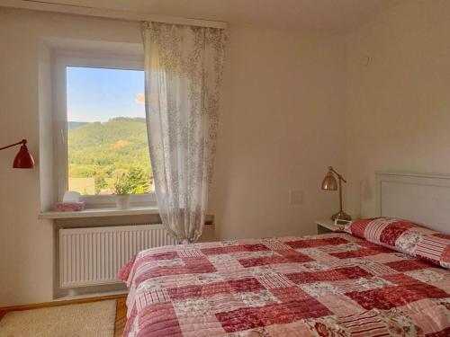 a bedroom with a bed and a window with a view at Tutaj Sielankowo in Ustroń