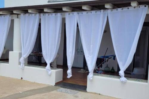 a group of white curtains on a stage at Casa Eoliana in Lipari