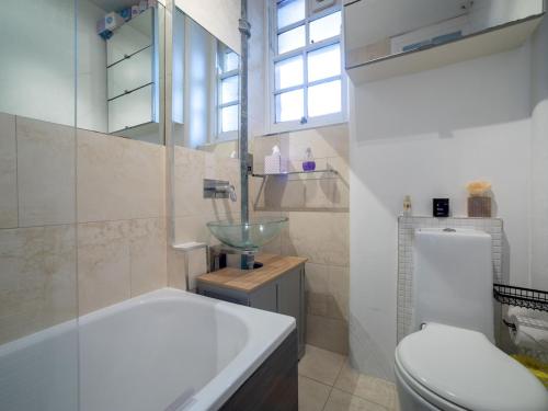 a bathroom with a tub and a sink and a toilet at Pass the Keys One bedroom APT near popular London attractions in London