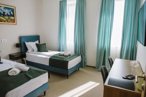 a hotel room with two beds and a table at AVIOR Garni Hotel in Subotica