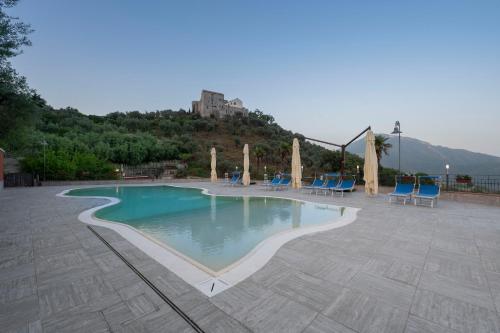 a swimming pool with chairs and a castle in the background at Agriturismo A casa di Anna in Pellezzano
