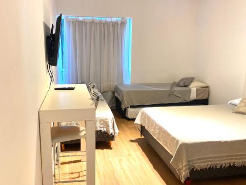 a small room with two beds and a television at Apart hotel Ciudad de Bs As in Buenos Aires