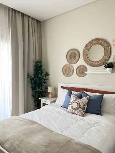- une chambre dotée d'un lit avec des oreillers et des miroirs au mur dans l'établissement Jebel Sifah Golf View Apartment, à Mascate
