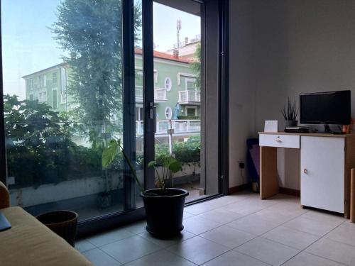 uma sala de estar com um vaso de plantas em frente a uma janela em Bilocale vista mare em Cattolica