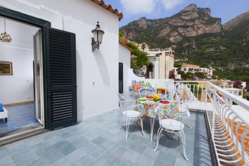 a balcony with tables and chairs with a view of the mountains at Estate4home- La casa del Maresciallo in Positano