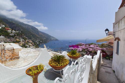 a view of the ocean from a balcony with chairs and flowers at Estate4home- La casa del Maresciallo in Positano