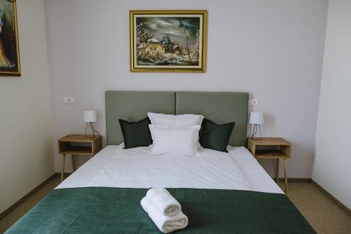 a bedroom with a bed with a towel on it at AVIOR Garni Hotel in Subotica
