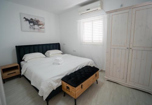 a bedroom with a large bed with a black headboard at Netanya Central SEA & SHOP in Netanya
