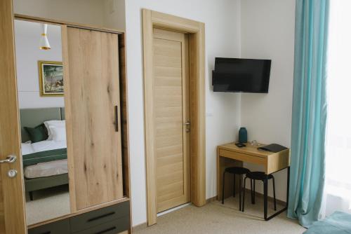 a room with a bedroom with a bed and a desk at AVIOR Garni Hotel in Subotica